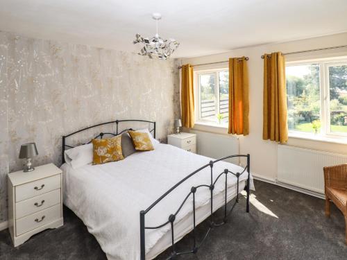 a bedroom with a bed and two windows at 8 Heatons Bridge Road in Ormskirk