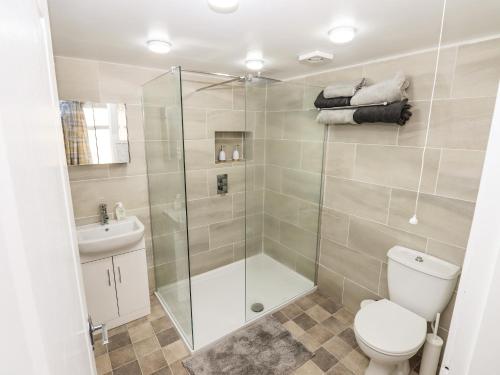 a bathroom with a shower and a toilet and a sink at 8 Heatons Bridge Road in Ormskirk