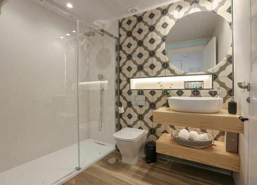 a bathroom with a sink and a toilet and a mirror at VELALMA DÚPLEX centro histórico in Jaén