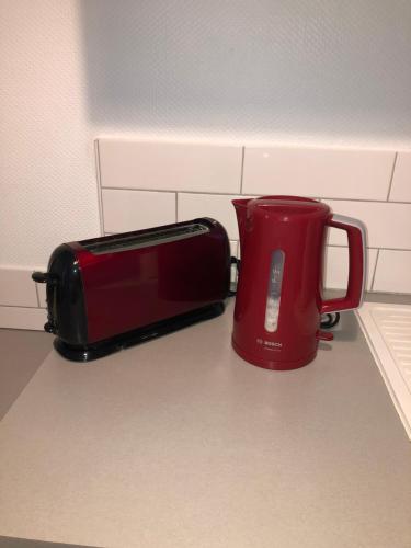 a red toaster sitting on a counter next to a toaster at Villa Marmillons in Aix-les-Bains