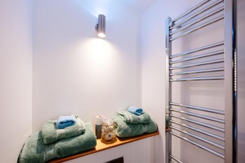 un bagno con asciugamani verdi su un bancone accanto alla doccia di Mount View Overnight Accommodation a Penzance