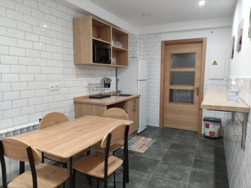a kitchen with a wooden table and chairs at Pension Cando in Porriño