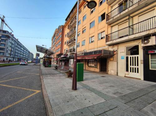 uma rua vazia numa cidade com edifícios em Pension Cando em Porriño