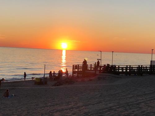 a group of people on the beach at sunset at House Turi in Ardea