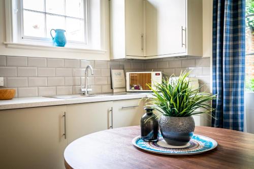 een keuken met een tafel met een potplant erop bij Middlethorpe Manor - No 5 Lazy Days and Explore in York