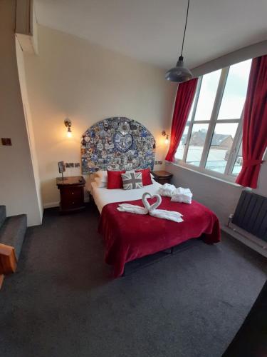 a hotel room with a bed with a red blanket at Potbank in Stoke on Trent