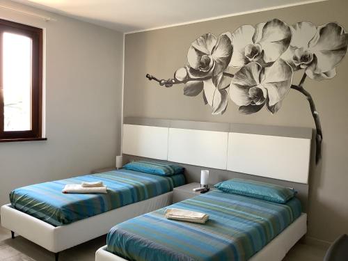 two beds in a room with a painting on the wall at VILLAFIORE in Azzano San Paolo