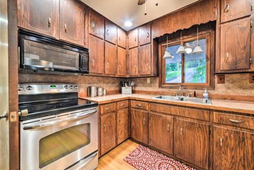 a kitchen with wooden cabinets and a stainless steel appliance at Charming Lakefront Home with Grill and Fire Pit! in New Concord