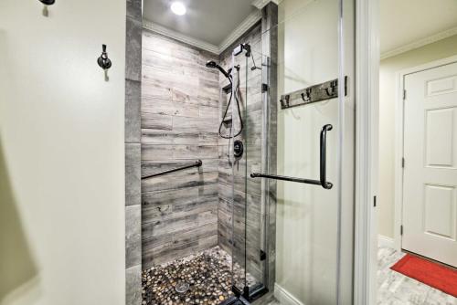 a bathroom with a shower with a glass door at Charming Lakefront Home with Grill and Fire Pit! in New Concord