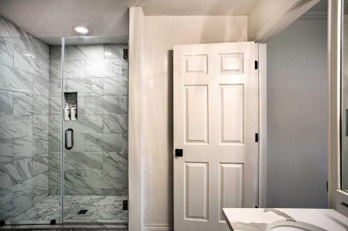 a bathroom with a shower and a white door at Remodeled Cedar Creek Lake Retreat with Fire Pit! in Malakoff