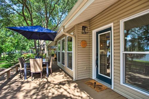 a porch with a table and an umbrella at Remodeled Cedar Creek Lake Retreat with Fire Pit! in Malakoff