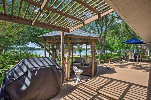 a wooden gazebo on a deck with a couch and a chair at Remodeled Cedar Creek Lake Retreat with Fire Pit! in Malakoff
