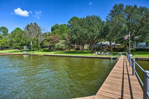 a dock on a lake with a house in the background at Remodeled Cedar Creek Lake Retreat with Fire Pit! in Malakoff