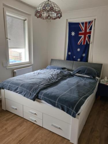 a bed in a bedroom with a flag on the wall at Charmantes helles Zimmer zentrumnah und naturnah in Göppingen