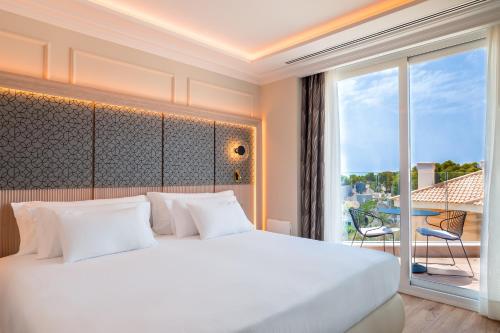 a bedroom with a white bed and a large window at Barceló La Nucía Palms in La Nucía