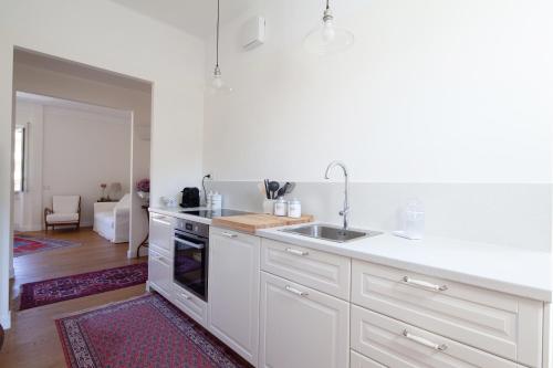 a white kitchen with a sink and a stove at La mia casa a Levante in La Spezia