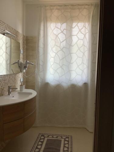 a bathroom with a sink and a shower curtain at VILLAFIORE in Azzano San Paolo