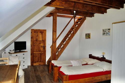 a bedroom with a bed and a stair case at Penzion U Anděla in Zdíkov