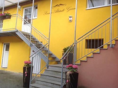 a yellow building with stairs and flowers on it at Pension Altstadt Garni in Bad Windsheim