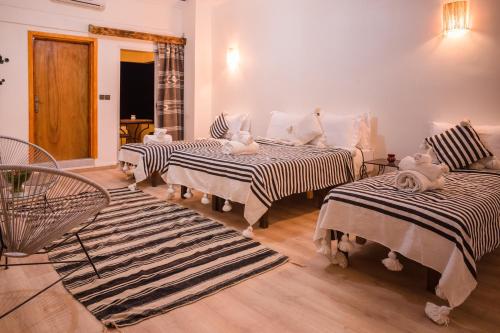 a room with three beds with stuffed animals on them at RIAD TUMAST in Aït Slimane