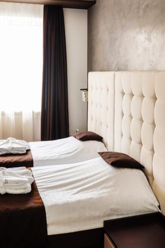 a bedroom with two beds and a large window at Verhovel Hotel in Verkhovyna