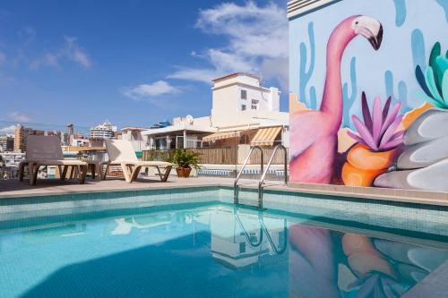 a swimming pool with a mural on the side of a building at Apartamentos Mayal con Piscina in Benidorm