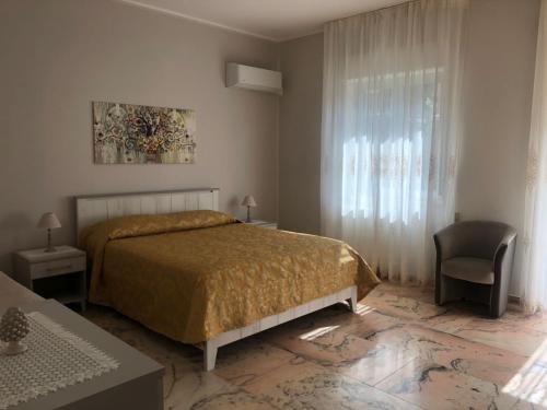 1 dormitorio con 1 cama, 1 silla y 1 ventana en CASA DI LUCIA, en Forza dʼAgro