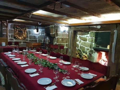 a long table with a red table cloth and glasses at Casa Dos Gomes in Viseu