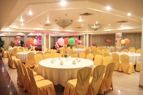un salón de banquetes con mesas, sillas y globos en De Luxe Hotel, en Cagayan de Oro