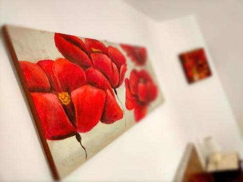 a painting of a red flower on a wall at CalmasinoRooms in Calmasino