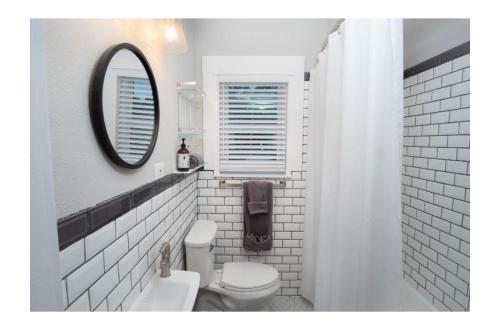 a white bathroom with a toilet and a mirror at Remodeled Modern 1BR1BA Apt Near Downtown, 5min Pearl in San Antonio