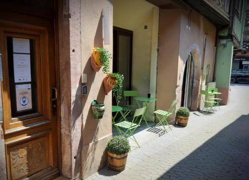 un bâtiment avec des plantes en pot sur son côté dans l'établissement A Mi Chemin, à Obernai