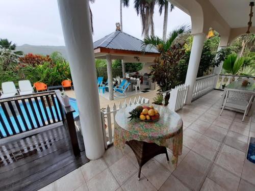 a table with a bowl of fruit on a porch at Royal Bay Villa in Anse Royale