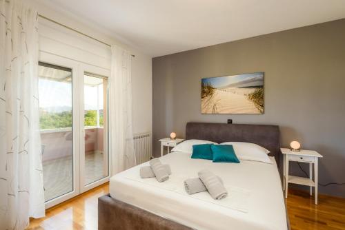a bedroom with a bed and a large window at Villa Jerkovic in Metković