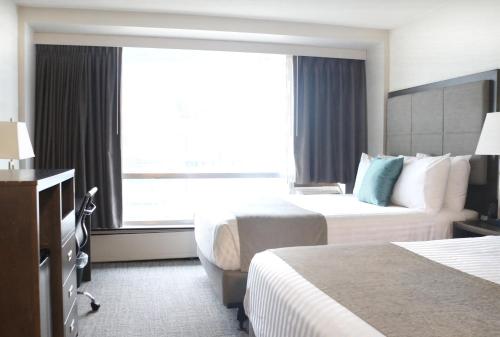 a hotel room with two beds and a window at Best Western Plus Sands in Vancouver