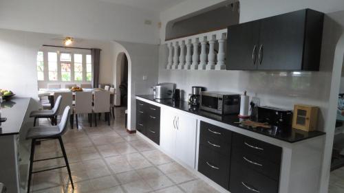a kitchen with black cabinets and a dining room at Royal Bay Villa in Anse Royale