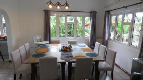 a dining room with a table and chairs and windows at Royal Bay Villa in Anse Royale
