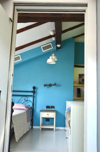 a bedroom with blue walls and a bed and a table at Mansarda Teatro Duse Centro in Bologna