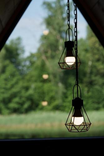 a pair of lights hanging from a window at Aleksandra Viesu Namiņš in Aglona