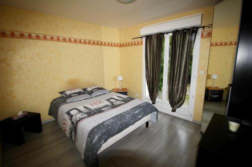 a bedroom with a bed and a window at Maison indépendante, au calme, charme et confort in Bérou-la-Mulotière
