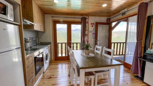 a kitchen with a table and a dining room with at Quinta da Resteva-Chalé do RIO in Vieira do Minho