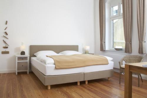 a bedroom with a bed and a table and a window at Ferienwohnungen Schlei 42 in Schleswig