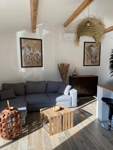 uma sala de estar com um sofá azul e uma mesa em Petit nid douillet en Luberon avec spa em Ansouis