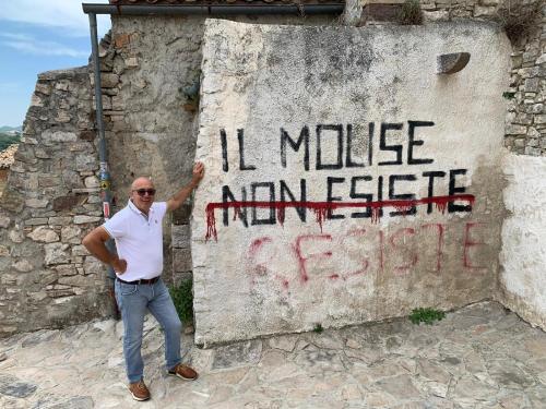 a man standing next to a sign with writing on it at La Quiete in Montenero di Bisaccia