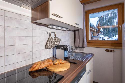 a kitchen with a counter with some bread on it at Malmurainza in Samnaun