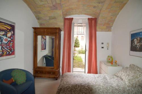 a bedroom with a bed and a mirror and a chair at La casa della mia famiglia in Rome