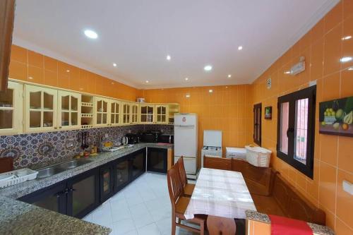 Il dispose d'une grande cuisine avec une table et un réfrigérateur. dans l'établissement Large House in Tangiers with Garage, à Tanger