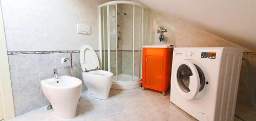 y baño con aseo y lavadora. en Artemide Residence en Isernia