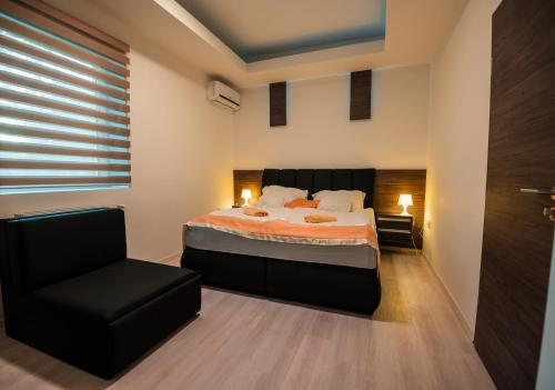 1 dormitorio con 1 cama y 1 silla en Club Hotel Pegasus en Tiszaug