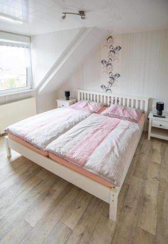 a bedroom with a large white bed in a room at Ferienwohnung am Starenkasten in Berumbur